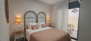 a bedroom with a large bed and a balcony at Malvagon Isla Canela los flamencos in Isla Canela +25 photos