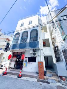 un edificio bianco con finiture blu su una strada di 150平米の丸々貸切のお部屋で国際通りまで徒歩圏内の最大宿泊14名可能 a Naha