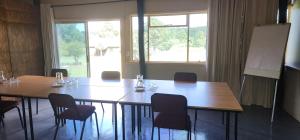 a room with a table and chairs and a board at Greystone Lodge in Dullstroom