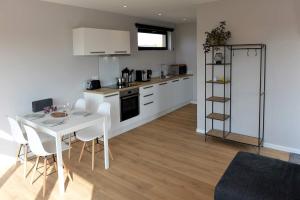 a kitchen with a table and chairs and a kitchen with white cabinets at Annexe de Barth in Erbaut