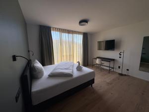 a bedroom with a bed with a desk and a window at New Age Boardinghaus Bad Rappenau in Bad Rappenau