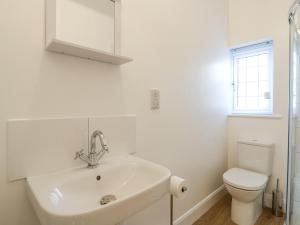 a white bathroom with a sink and a toilet at Little Danns in Hailsham +35 photos