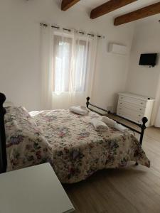a bedroom with a bed and a dresser and a window at Bed breakfast L'AMICO in Alghero