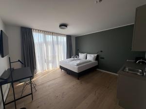 a bedroom with a bed and a large window at New Age Boardinghaus Bad Rappenau in Bad Rappenau