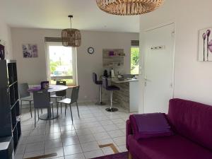 a living room with a purple couch and a table at Le Pourpre, T2 proche plage de Morgat in Crozon