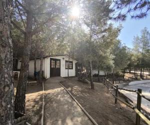 a white house with trees in front of it at Alua Centro de Ocio - Camping Valdearenas in Iznájar