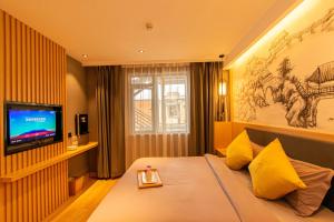 a hotel room with a bed and a television at Gongxili-Yinjian Hotel in Kunming