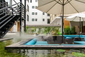 a pool with an umbrella in the water at Gongxili-Yinjian Hotel in Kunming