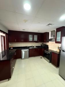 una grande cucina con armadi marroni ed elettrodomestici neri di Horizon Rooms JBR a Dubai