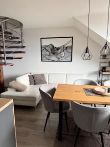 a living room with a table and a couch at Apartman pod Smokovcom in Dolný Smokovec
