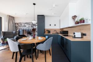 a kitchen and dining room with a wooden table and chairs at Apartamenty Rocha in Pabianice