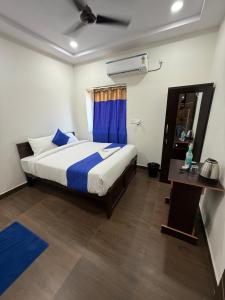 een slaapkamer met een groot bed en een blauw gordijn bij COCO NET Hotel in Ibrāhīmpatan