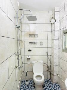 a bathroom with a toilet and a shower at KJM Home in Douala +16 photos