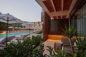 a resort with a pool with chairs and umbrellas at Cala San Miguel Ibiza Resort, Adults only, Curio Collection by Hilton in Puerto de San Miguel