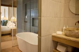 a bathroom with a bath tub and a sink at Cala San Miguel Ibiza Resort, Adults only, Curio Collection by Hilton in Puerto de San Miguel