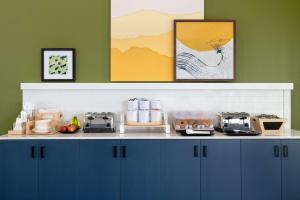 a kitchen with blue cabinets and a counter with food at Spark By Hilton Santa Nella in Santa Nella