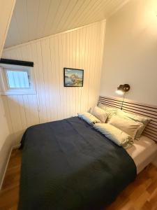 a bedroom with a large bed with a black blanket at Panorama X Apartment 5 min from Reine, Hamnøy and Bodø ferry in Moskenes +44 photos