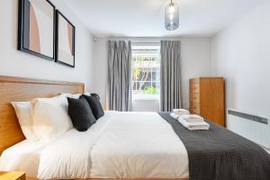 a bedroom with a bed with white sheets and pillows at Bridgeview Retreat, 2Bed 2Bridge in London