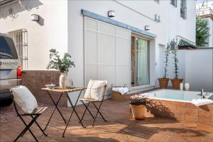 セビリアにあるMagno Apartments Roblesのパティオ(テーブル、椅子、バスタブ付)