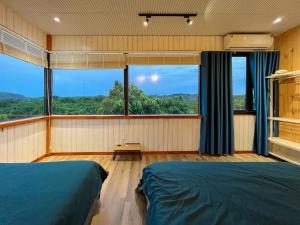 a bedroom with a bed and a large window at The Lake House Retreat & Watersports in Tân Phú