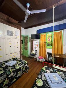 a bedroom with two beds and a ceiling fan at G H Hostal VIP in Buenos Aires