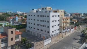 ein hohes weißes Gebäude in einer Stadt mit Gebäuden in der Unterkunft 2 Bedroom 2 Bathroom Apartment in Corales del Sur - Parque del Este - Airport in La Viva