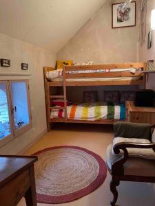 a bedroom with two bunk beds and a rug at Petite maison des Boirôts 3 chambres in Lenax
