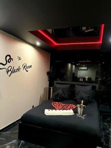 a black room with a bed and a red light at Romantique room,balnéo,mirroir,parking in Grenoble