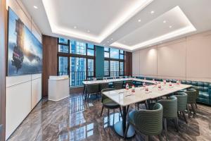 a conference room with tables and chairs and large windows at Merrihod Hotel - Guangzhou South Station Jinlong Subway Station Branch in Shunde
