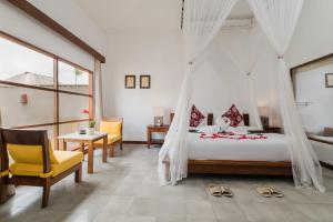 a bedroom with a bed with a mosquito net at Alam Puisi Villa Ubud in Ubud