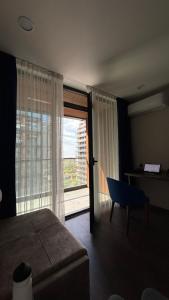 a bedroom with a bed and a desk and a window at Adlia Flight Spot in Batumi