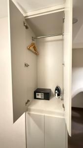 a small kitchen with white cabinets and a shelf at Adlia Flight Spot in Batumi