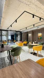 a restaurant with tables and chairs in a room at Adlia Flight Spot in Batumi