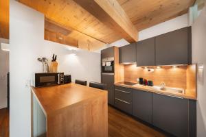 a kitchen with a counter with a microwave and a sink at Das Sill by Inncomer in Innsbruck