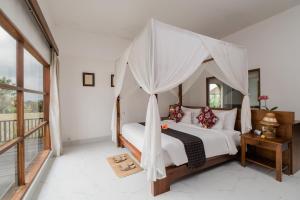 a bedroom with a bed with a canopy at Alam Puisi Villa Ubud in Ubud