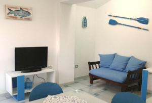 a living room with a tv and a blue chair at The Blue Lighthouse in SantʼAntìoco