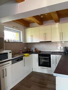 a kitchen with white cabinets and a sink at PontyParádé in Fonyód +7 photos