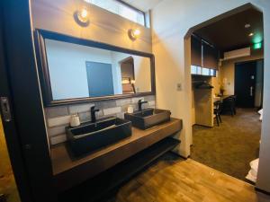 Un baño con dos lavabos y un espejo grande. en Js STAY OTARU II, en Otaru 15 fotos más