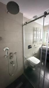 a bathroom with a shower with a toilet and a sink at Adlia Flight Spot in Batumi +31 photos