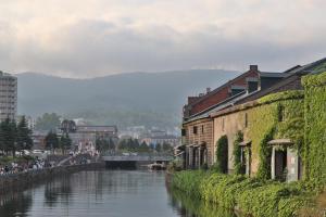 Un río en una ciudad con edificios y un puente. en Js STAY OTARU II, en Otaru