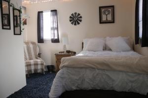 una camera da letto con un letto e una sedia di River Lane Cottage a Dunnville