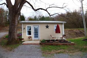 una piccola casa con due sedie e una stella sopra di River Lane Cottage a Dunnville