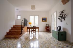 a living room with a staircase and a table and chairs at Villa Rubino - Camere in Palermo