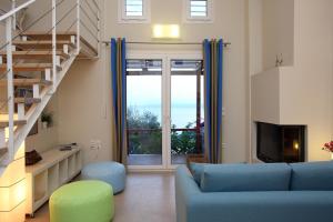 a living room with a blue couch and a staircase at Elies Houses in Agnontas