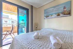 a bedroom with a white bed with towels on it at Santos Lerch Sol Apartment in Puerto de Santiago +40 photos