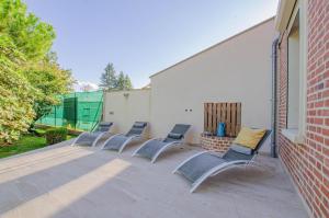 a row of chairs sitting on a patio at Manon des lacs in Mesnil-Saint-Père