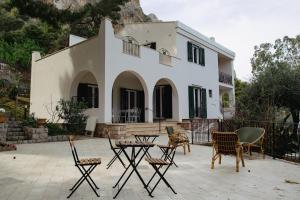 a house with chairs and tables in front of it at Villa Rubino - Camere in Palermo