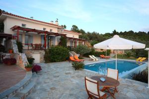 a patio with a table and chairs and a pool at Elies Houses in Agnontas
