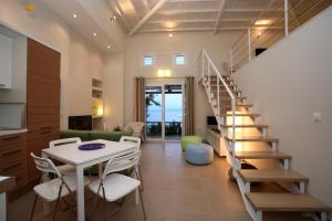 a living room with a staircase and a table and chairs at Elies Houses in Agnontas