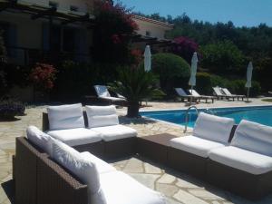 a group of white chairs sitting next to a pool at Elies Houses in Agnontas